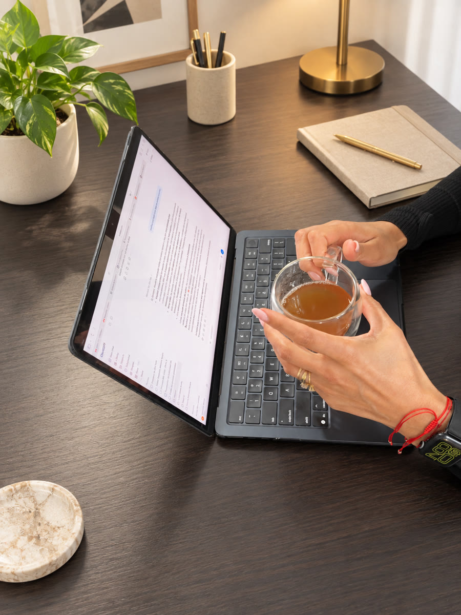 Genesis working at her laptop with a cup of tea